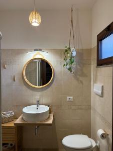 y baño con lavabo, aseo y espejo. en B&B Zio Cici, en Minervino di Lecce