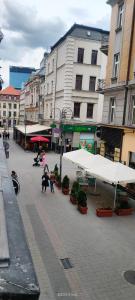 a group of people standing in a street with buildings at Lovely apartment on Dyrekcyjna street! In the very center of Katowice! in Katowice