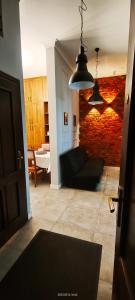 a living room with a black couch and a brick wall at Lovely apartment on Dyrekcyjna street! In the very center of Katowice! in Katowice