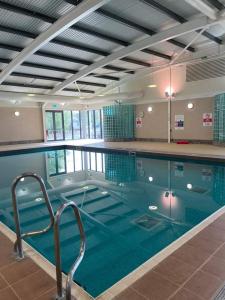 a large swimming pool with blue water in a building at Daisy's luxury caravan at tattershall lakes in Lincoln