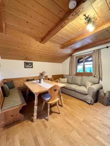 ein Wohnzimmer mit einem Tisch und einem Sofa in der Unterkunft Ferienwohnung Haus Reindl in Walchensee