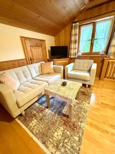 ein Wohnzimmer mit einem Sofa und einem Couchtisch in der Unterkunft Ferienwohnung Haus Reindl in Walchensee