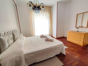 um quarto com uma cama branca com um espelho e uma cómoda em Elegante appartamento a Cefalù em Cefalù