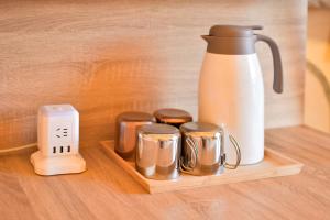 a coffee maker and four coffee cups on a wooden tray at 柴口岸 Chaikuo Waterfront in Green Island