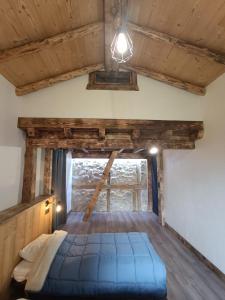 a bedroom in a log cabin with a blue bed at Les étoiles de Bevy Gîtes in Lajoux