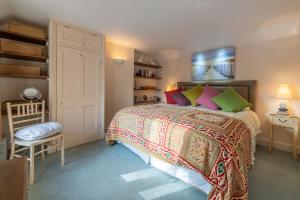 1 dormitorio con 1 cama grande y almohadas coloridas en The Manse en South Creake