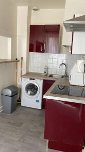 a kitchen with a washing machine and a sink at Comfy Parisian studio! in Ivry-sur-Seine