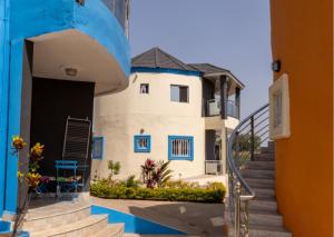 a house with blue and white walls and stairs at Lovely 13-Bed Complex on Cape Point Beach Bakau in Bakau