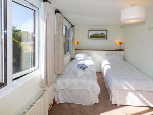 two beds in a room with a window at Woodlands in Milverton