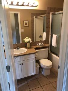 a bathroom with a toilet and a sink and mirror at Paradise Canyon Golf Resort, Luxury Villa 409 in Lethbridge