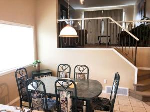 a dining room with a table and chairs and a staircase at Paradise Canyon Golf Resort, Luxury Villa 409 in Lethbridge