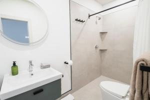 Baño blanco con lavabo y espejo en Bed and Breakfast du Village BBV, en Montreal
