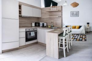 a kitchen with white cabinets and a table with chairs at Dohány Street Delight in Budapest