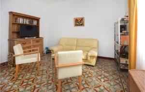a living room with a couch and a tv and chairs at 2 Bedroom Lovely Apartment In Als in Alès