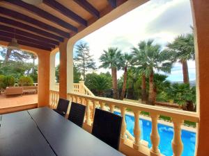 a porch with a table and a view of a pool at Villa Alemania in Altea