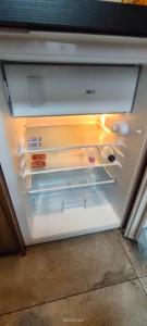 an empty refrigerator with its door open in a room at Lovely apartment on Dyrekcyjna street! In the very center of Katowice! in Katowice