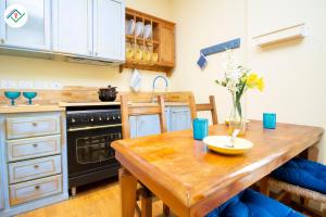 a kitchen with a wooden table and a stove and sink at Vedo il Mare by TuscanyWeGo in Livorno +16 photos