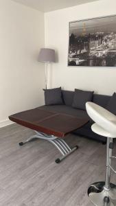 Bett in einem Zimmer mit Sofa und Tisch in der Unterkunft Comfy Parisian studio! in Ivry-sur-Seine