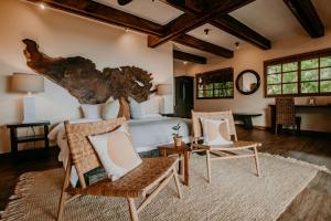 a living room with a bed and two chairs at Sansara Surf Yoga & Resort in Cambutal