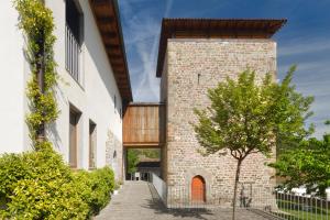 une vue extérieure sur un bâtiment en briques avec un arbre dans l'établissement Hotel Rural Torre de Úriz, à Uriz