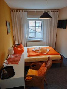 ユーターボークにあるHermanns Hotel Zum Goldenen Sternのベッド2台、椅子、窓が備わる客室です。