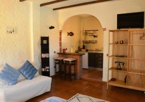 sala de estar con sofá blanco y cocina en Cortijo Petra en Villanueva del Rosario