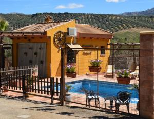 a house with a swimming pool with a fence at Cortijo Petra in Villanueva del Rosario
