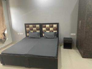 ein Schlafzimmer mit einem großen Bett mit blauer Bettwäsche und Kissen in der Unterkunft OYO H.l Homes Near Bestech Central Square Mall in Gurgaon