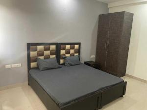 ein Schlafzimmer mit einem großen Bett und einem Schrank in der Unterkunft OYO H.l Homes Near Bestech Central Square Mall in Gurgaon