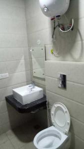 ein Badezimmer mit einem weißen WC und einem Waschbecken in der Unterkunft OYO H.l Homes Near Bestech Central Square Mall in Gurgaon