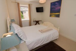 a bedroom with a white bed and a window at Lodge End in Heacham