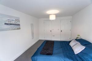 May Disc - Long Stay - Contractors في سويندون: غرفة نوم بسرير ازرق ولوحة