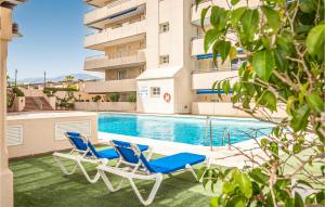 Duas espreguiçadeiras e uma piscina em frente a um edifício em 1 Bedroom Cozy Apartment In Marbella em Marbella