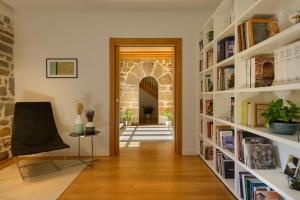 UrizにあるHotel Rural Torre de Úrizの白い本棚と椅子が備わる廊下