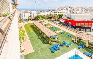 uma vista sobre um relvado com espreguiçadeiras e o oceano em 1 Bedroom Cozy Apartment In Marbella em Marbella