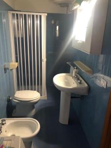 ein Badezimmer mit einem weißen Waschbecken und einem WC in der Unterkunft GC Petit Palais Lampedusa in Lampedusa