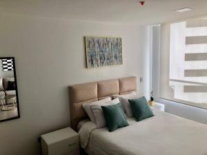 a bedroom with a large bed with green pillows at Suite en la mejor zona de Quito in Quito