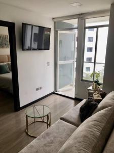 a living room with a couch and a glass table at Suite en la mejor zona de Quito in Quito