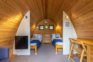 a room with two beds and a tv in a cabin at Columbine Cottage in Holme next the Sea