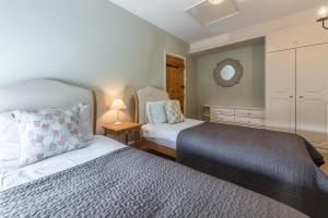 a small bedroom with two beds and a mirror at Columbine Cottage in Holme next the Sea