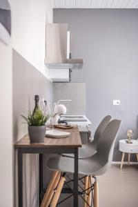uma cozinha com uma mesa de madeira e 2 cadeiras em Suite 649 Mono con terrazzo em Modena