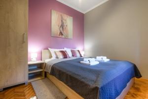 een slaapkamer met een groot bed met paarse muren bij DuMalux Velvet in Subotica