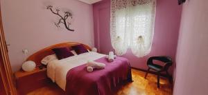 um quarto com uma cama com paredes cor-de-rosa e uma cadeira em MyHouseSpain - Apartamento 2 habitaciones cerca de la playa em Gijón