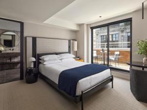 a bedroom with a large bed and a large window at Hotel AKA NoMad in New York