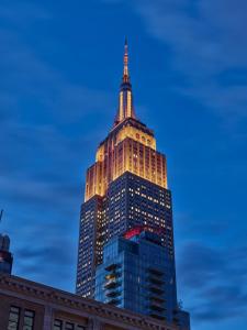 een hoog gebouw verlicht in de nacht bij Hotel AKA NoMad in New York