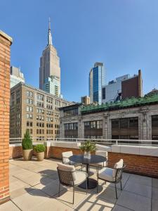 een patio met een tafel en stoelen op een dak bij Hotel AKA NoMad in New York