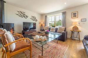 uma sala de estar com um sofá e uma mesa em Sea Holly Cottage em Thornham