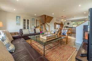 een woonkamer met een bank en een tafel bij Sea Holly Cottage in Thornham