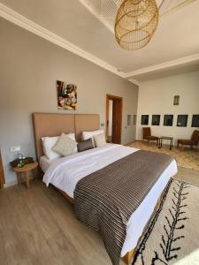 een slaapkamer met een groot bed en een tafel bij AdaZen Ecolodge in Azilal