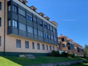 - un grand bâtiment avec des fenêtres sur le côté dans l'établissement El Rincón del Reloj, à Llanes